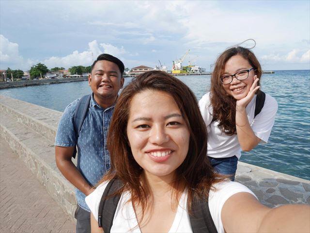 フィリピン留学時代、友人２人と海をバックに。